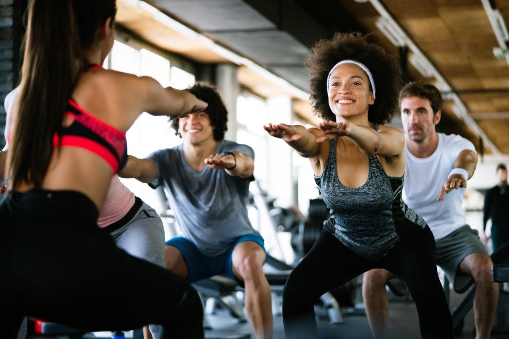 Diversity group of people training in a gym. Trainer and sportive persons exercising